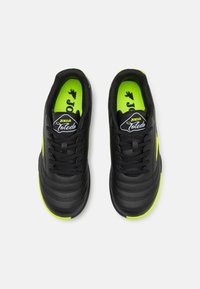 Zapatillas deportivas negras con un upper de cuero texturizado, acentos en verde lima y cordones negros. Cuenta con una plantilla acolchada con la marca.