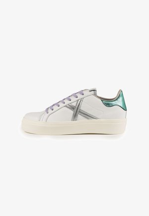 White leather sneaker with silver accents, purple laces, and a teal heel. Features a chunky sole and a sleek design.