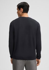Donker langshirt met lange mouwen, gemaakt van textiel met een structuur, ronde hals en een relaxed fit. De achterkant heeft een naadloos ontwerp met een rechte zoom.