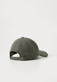 Casquette en laine olive avec une couronne structurée, une visière incurvée et une sangle réglable avec un petit détail en métal.