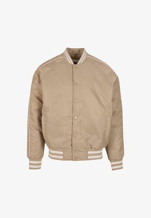 Beez bomber-jope, millel on sile ja läikiv tekstuur. Omab valgeid triibusid krael ja varrukaotsadel, koos nööpidega kinni pandud sulgemisega.