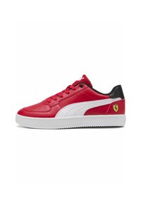 Tenisi roșii din piele cu accente albe, suprafață texturată, vârf rotund, talpă albă plată și un mic logo galben Ferrari la călcâi.