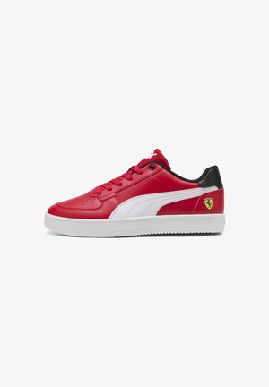 Sarkanskā ādas sporta kurpe ar baltām akcentiem, teksturēta virsma, apaļa purngalu, plakana balta zole un neliels dzeltenais Ferrari logo uz papēža.