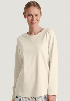 Maglietta a maniche lunghe color crema con scollatura rotonda e dettagli a costine. Tessuto morbido e liscio con una vestibilità rilassata.