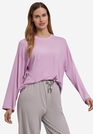 Camicia rosa chiaro a maniche lunghe con vestibilità ampia e scollo tondo, abbinata a pantaloni grigi con coulisse, realizzati in un tessuto morbido e liscio.