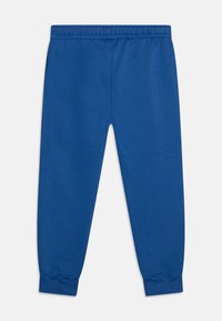 Pantalon de survêtement léger bleu avec une taille élastique, des poignets fuselés et une texture lisse. Pas de poches ni de détails matériels visibles.