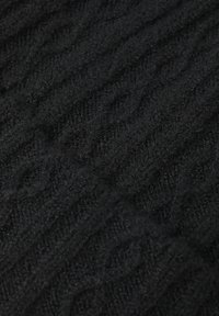 Tessuto a maglia nero con un motivo testurizzato e in rilievo. Texture morbida e fibrosa con un aspetto marmorizzato, ideale per capi di abbigliamento caldi.
