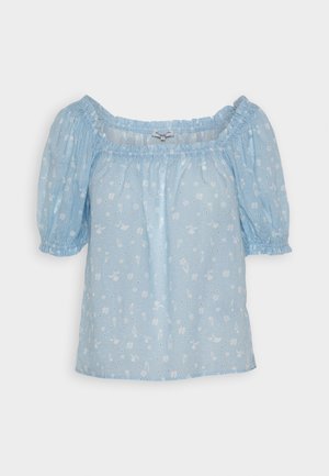 Gaiši zila blūze ar atplatu plecu kaklu, pūkainām piedurknēm un ziedu rakstu. Izgatavota no mīksta auduma ar smalkām tekstūrām.