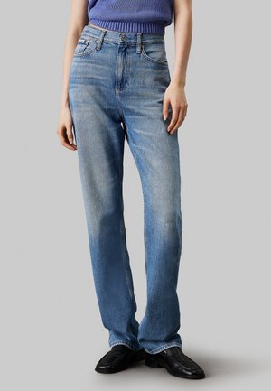 Jeans de mezclilla azul claro con un corte relajado, cintura alta y textura desgastada. Presentan un diseño clásico de cinco bolsillos y detalles de metal.