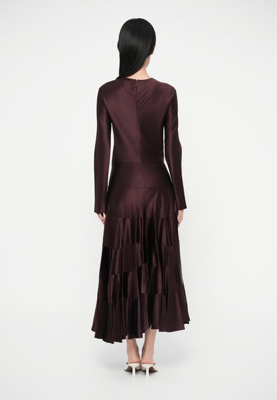 Dolga bordo obleka z dolgimi rokavi in večplastno krinolino, izdelana iz satena, z oprijetim zgornjim delom in gladko teksturo. Prikazan zadnji pogled.