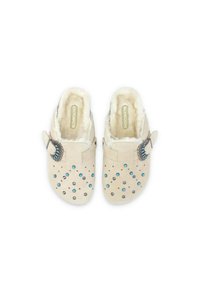 Zoccoli beige senza lacci con fodera in pelliccia sintetica, accentuati da borchie argentate e turchesi. Presentano una fibbia laterale decorativa e un design perforato.