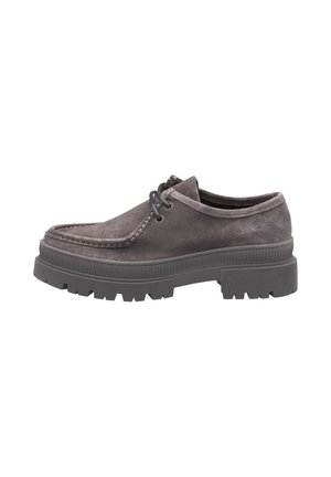 Chaussure en suède gris foncé à lacets avec une semelle en caoutchouc texturée épaisse et un détail de coutures surélevées autour de la zone des orteils.
