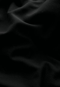 Tessuto nero con una texture liscia e leggermente lucida, che mostra pieghe e grinze sottili, creando un effetto visivo dinamico.