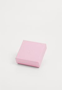 Caixa de cartão cor-de-rosa com uma textura suave, apresentando um logótipo em relevo e forma octagonal, desenhada para embalar itens de forma segura.