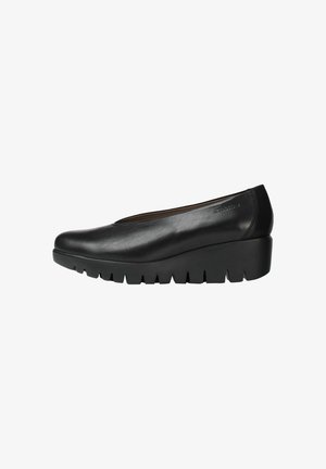 Zapatos de cuña de cuero negro con punta redondeada y suela dentada pronunciada. Diseño elegante con detalles mínimos.