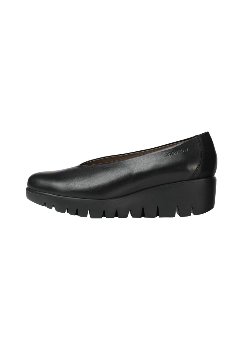 Zapatos de cuña de cuero negro con punta redondeada y suela dentada pronunciada. Diseño elegante con detalles mínimos.