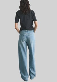 Lichtblauwe hoge taille brede jeans met een klassieke vijf-pocket ontwerp en een licht vervaagde textuur. De achterkant toont gestikte zakken.