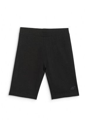 Dziewczyna w różowej czapce i swetrze, czarne krótkie spodenki rowerowe, białe skarpetki, czarno-białe trampki, trzyma pasek czarnej torby na ramię.