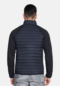 Zwarte en marineblauwe jas met een gevoerde rug en lange mouwen, met een hoge kraag en een gestructureerd patroon aan de achterzijde.