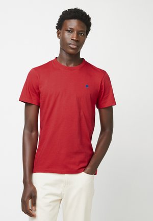 Rode katoenen t-shirt met een ronde hals en korte mouwen. Beschikt over een klein blauw geborduurd boomlogo op de linkerkant van de borst. Eenvoudig ontwerp.