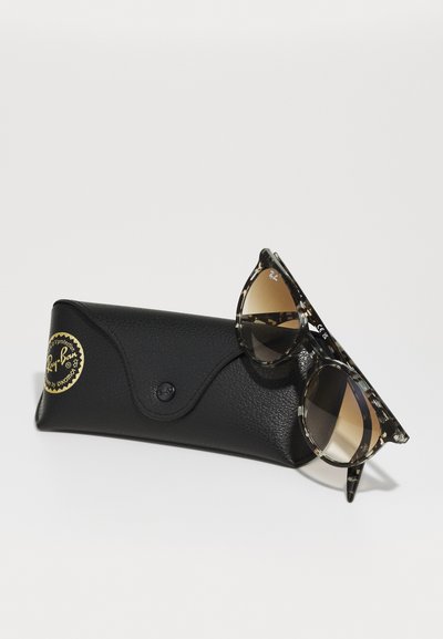 Слънчеви очила Ray-Ban с шаблонна черупка от костенурка и кафяви градиентни лещи, поставени върху черен кожен калъф с кръгъл логотип.