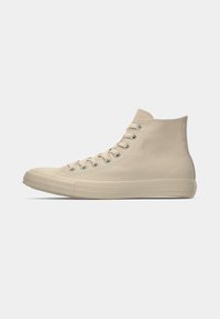 Beige canvas high-top sneaker met rubberen neuzenkap, vetersluiting aan de voorkant, ronde ooggaten en een textuur achterpaneel. Glad oppervlak met minimale branding.