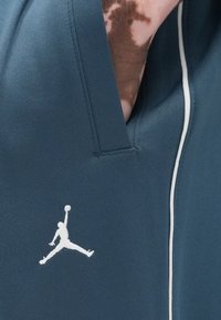 Τζελ αθλητική ζακέτα με λευκές λεπτομέρειες περιγράμματος. Διαθέτει κεντημένο λογότυπο Jumpman σε λευκό στο μπροστινό μέρος. Μαλακό, με υφή ύφασμα.