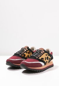 Sneaker multicolori con alcantara bordeaux e nera, dettagli in stampa leopardata, particolari in argento metallizzato e suole in gomma testurizzata.