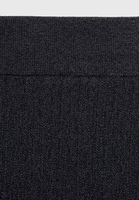 Tissu de couleur sombre avec un motif texturé et une taille élastique. Le matériau semble tricoté, avec un léger éclat et une structure épaisse et durable.