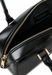 Borsa a mano in pelle nera con una texture liscia, dettagli in zip dorata e un design semplice e strutturato. L'interno presenta una fodera nera.