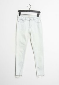 Jean skinny en denim clair avec un ourlet effiloché, doté d'un design classique à cinq poches et d'une fermeture à bouton et zip.