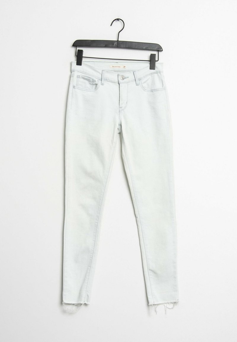 Jean skinny en denim clair avec un ourlet effiloché, doté d'un design classique à cinq poches et d'une fermeture à bouton et zip.