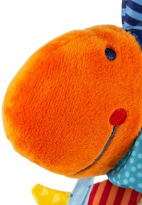 Peluche con una testa arancione e soffice al tatto. Presenta un tessuto blu con righe e pois, dettagli rossi e un volto sorridente ricamato.