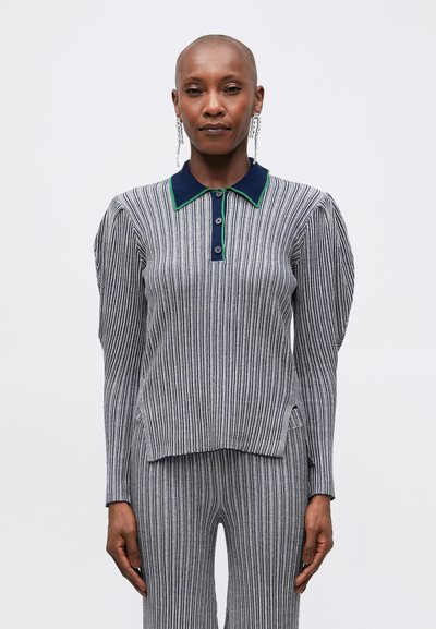 Striped long-sleeve polo in gray and navy with green accents. Features buttons and side slits. Worn with matching striped pants.