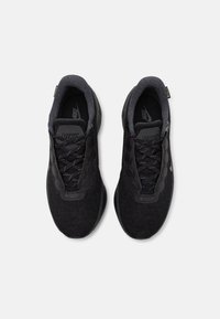 Svarte Nike joggesko med mesh-overdel, teksturerte detaljer, tradisjonell snøring, og en polstret såle for komfort.