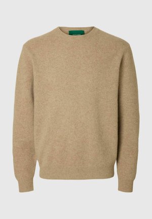 Pull-over en laine beige avec manches longues, col rond et ourlets côtelés. Texture douce avec un léger motif chiné. Étiquette verte visible.