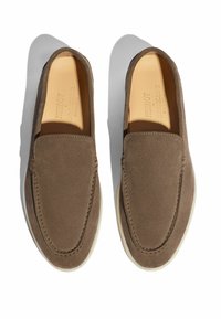 Brune ruskinds slip-on sko med en rund tå, der har en cremefarvet gummisål og minimal syning langs kanterne.