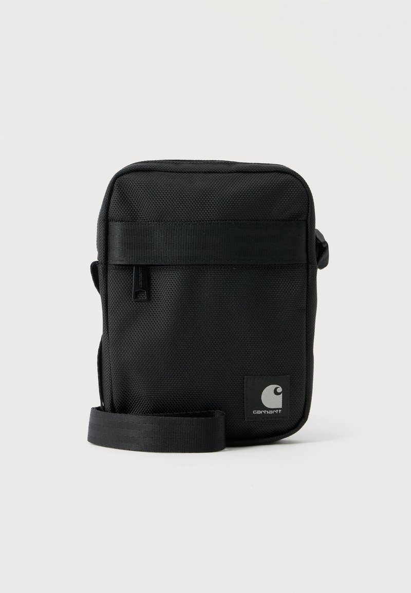 Μαύρη τσάντα Carhartt crossbody με εμπρόσθια τσέπη με φερμουάρ, ρυθμιζόμενο λουρί και λογότυπο στην κάτω δεξιά γωνία.