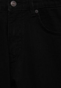 Pantalones vaqueros negros con un diseño clásico de cinco bolsillos, detalles de botones de cobre y una tela texturizada con un acabado suave.