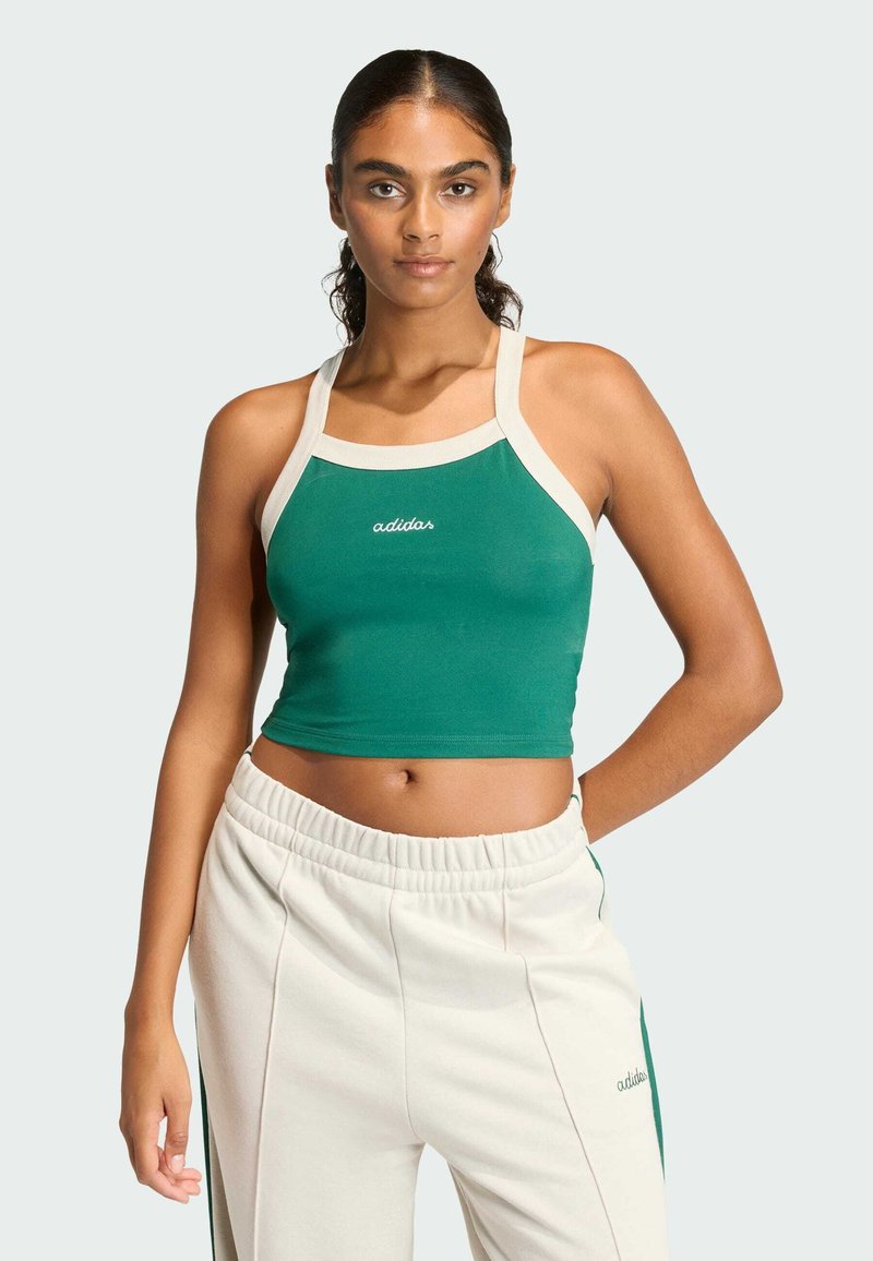 Zelený crop top s krémovými akcentmi a logom "adidas". Vyrobený z elastického materiálu, má široké ramienka a priliehajúci strih.
