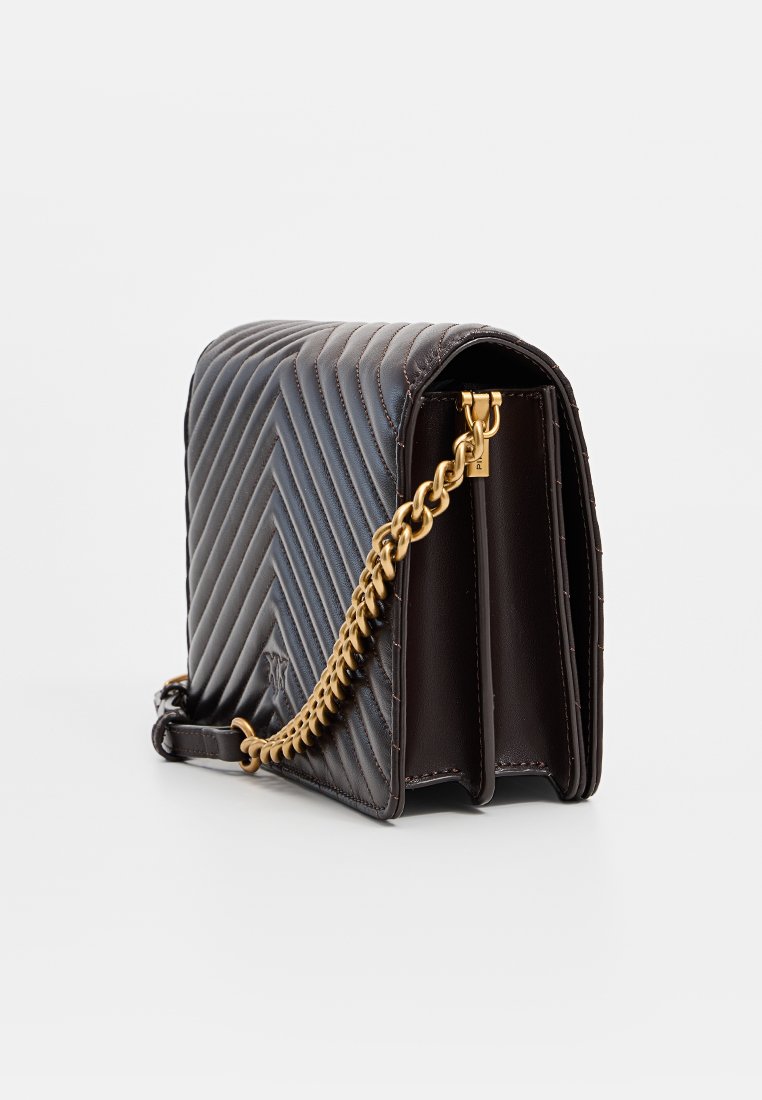 Brązowa pikowana skórzana torebka na łańcuszku w kolorze złotym, z wyraźnie zarysowanym kształtem i płaskim dnem. Zauważalny wzór chevron na powierzchni.