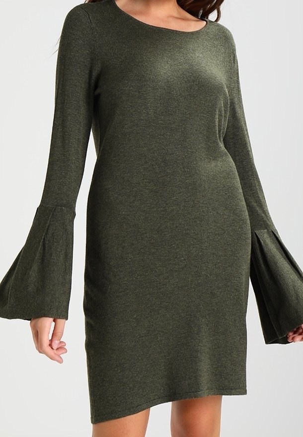 Olivgrön klänning i mjukt stickat tyg, med långa trumpetärmar och rund halsringning, med en figurnära silhuett och asymmetrisk nederkant.