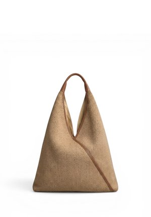 Suuri beige kudottu olkalaukku kolmionmuotoisena, ruskeilla nahkareunuksilla ja yhdellä olkahihnalla valkoisella taustalla.