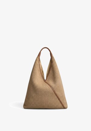 Large beige woven tote bag with triangular shape, brown leather trim, and single shoulder strap on a white background.