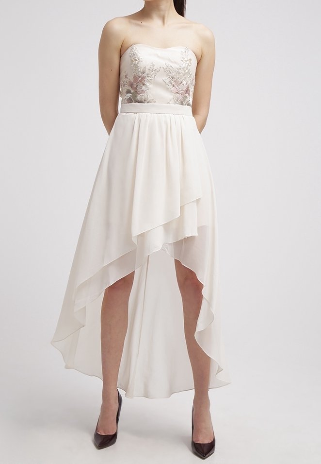 Olkaless iltamekko ivory-värissä, jossa on brodyyreilla koristeltu yläosa, virtaava epäsymmetrinen sifonkihame ja sileä satiinivyötärö.