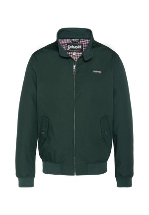 Veste bomber verte avec fermeture éclair à l'avant, deux poches latérales et poignets côtelés. Le col et la doublure sont ornés d'un motif à carreaux. Logo Schott affiché.