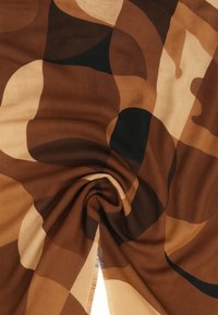 Tessuto a motivi astratti con forme curve nei toni del marrone, beige e nero, caratterizzato da una texture morbida e da una leggera lucentezza.