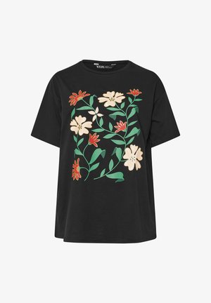 T-shirt nera a maniche corte con stampe di fiori crema e rossi e foglie verdi sulla parte anteriore.