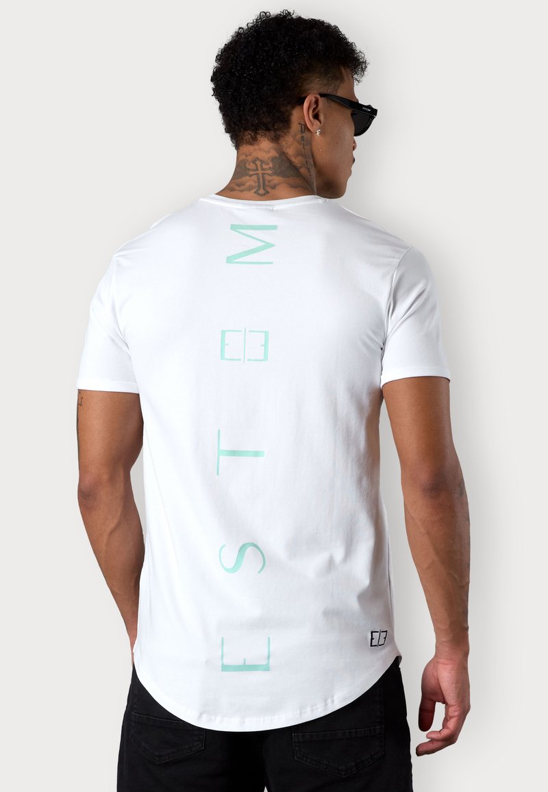 White short-sleeve t-shirt featuring vertical mint green text on the back. Soft cotton material with a rounded hem and relaxed fit.