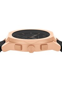 Orologio in tonalità oro rosa con quadrante nero, caratterizzato da una lunetta testurizzata, due pulsanti rialzati e un cinturino in silicone nero.